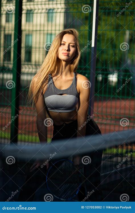 Stylish Blonde Girl With Perfect Body Posing With A Tennis Racket At