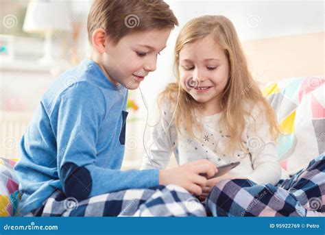 Two Happy Siblings Children Having Fun And Listening Music With Stock