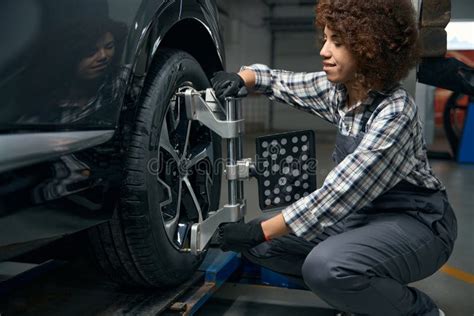 Woman Auto Mechanic Repairing A Wheel In A Car Workshop Stock Image