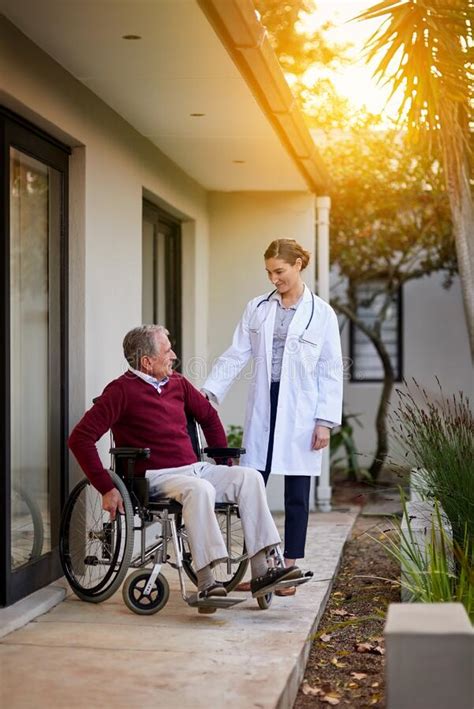 Race You To The Gate An Elderly Man In A Wheelchair Being Assisted By