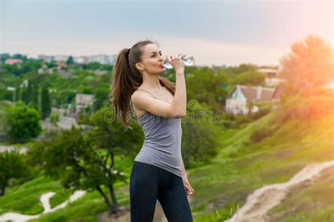 Thirsty Fitness Girl Holding Bottle Of Water Stock Photo Image Of