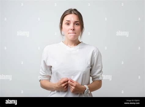 Portrait Of Beautiful Girl In White T Shirt Frowning Her Face In Displeasure Keeping Arms