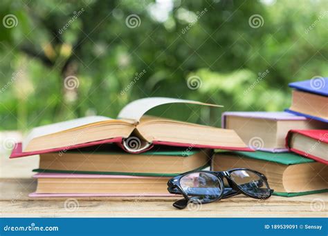 Open Book And Eyeglasses On A Wooden Table In A Garden Sunny Summer Day Reading In A Vacation