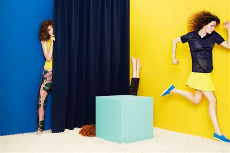 Two Women Jumping Up And Down In Front Of A Yellow Wall One Wearing