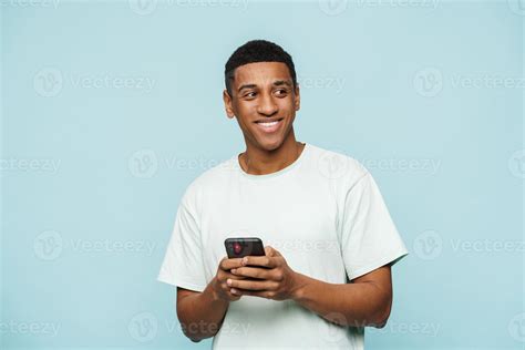 Smiling African Man Looking To The Side And Typing On His Phone Stock Photo At Vecteezy