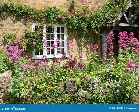 House Facade With Door And Window Overgrown With Creeper And Flowers