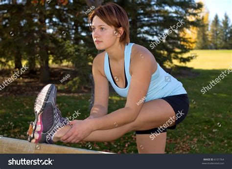 Young Woman Bending Over To Stretch Her Hamstrings Stock Photo 6131764