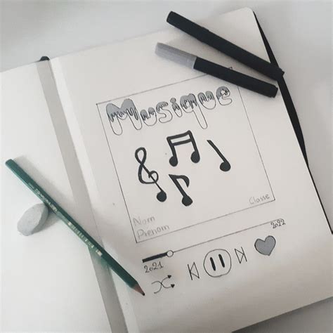 A Notepad With Music Notes And Pencils Next To It On A White Surface