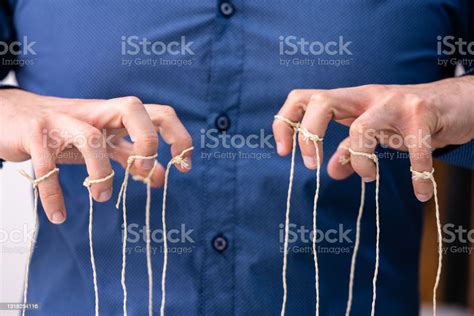 Manipulating Marionette Puppet Strings By Hand Stock Photo Download