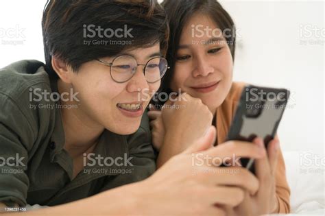 Young Lesbian Love Couple Doing Activities On The Bed With Happiness