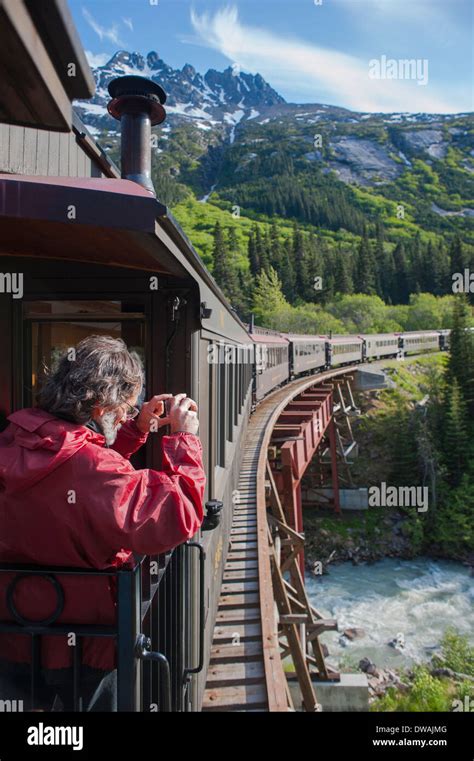 Passenger Photographing On The Historic White Pass Yukon Route Railroad Train As It Crosses A