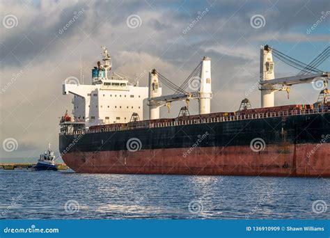 Cargo Ship Being Docked By Tug Boat Stock Image Image Of Water