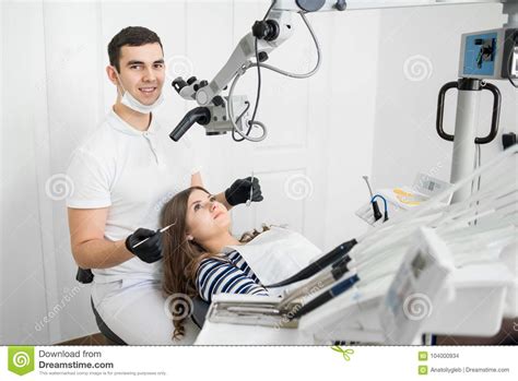 Friendly Male Dentist With Beautiful Female Patient During Treatment In