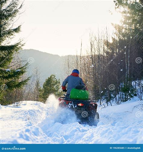 Rear View Of A Biker Driving Four Wheeler Atv In Winter In The