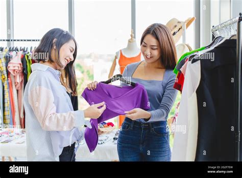 Women Customer Choosing Clothes In Fashion Shop With Business Owner Care Service With Happy