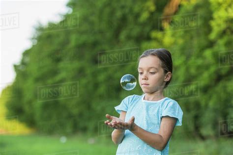 Girl Playing With Soap Bubble Outdoors Stock Photo Dissolve