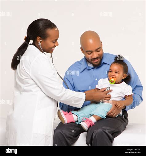 African American Female Pediatrician Examining Baby Girl Being Held By