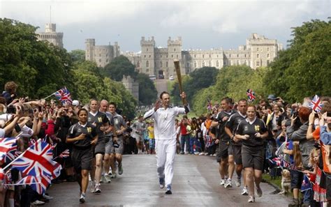 Torchbearer Alan Corbishley Carrying The Olympic Flame On The Torch