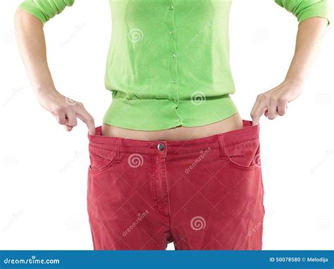 Woman Shows Her Weight Loss By Wearing An Old Big Trousers Stock Photo