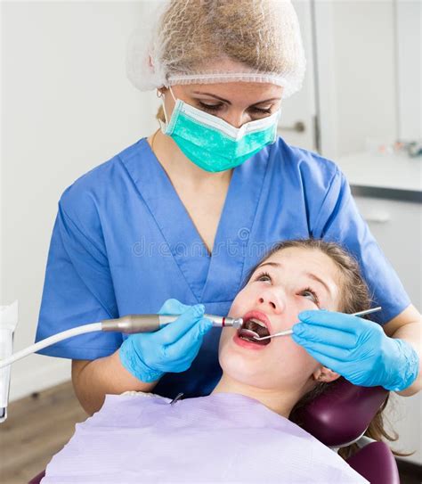 Female Dentist With Girl Patient During Oral Checkup Stock Image