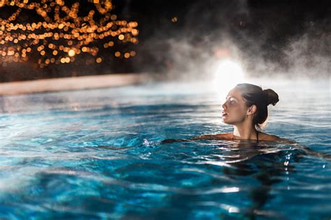 Young Woman Enjoying In A Heated Swimming Pool At Night Stock Photo