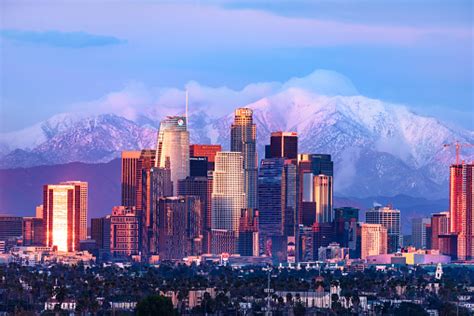 Downtown Los Angeles Skyline With Snow Capped Mountains Behind At