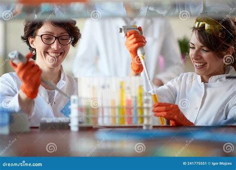 Young Female Chemistry Students Enjoy While Pipetting Colourful