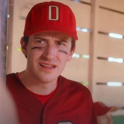 a man in a red baseball uniform is smiling