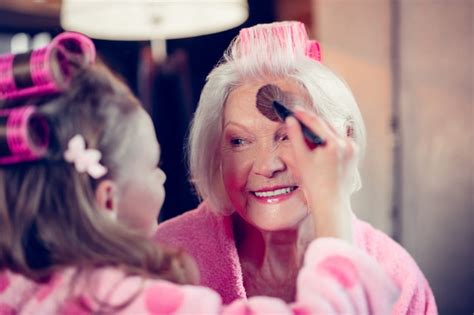 premium photo beautiful granny cute girl doing makeup for her beautiful granny putting some