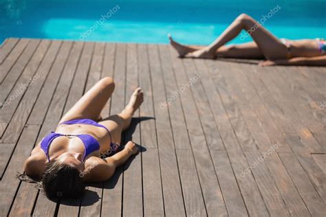 Mujeres En Bikini Tumbadas Junto A La Piscina Tomando El Sol Fotograf A De Stock