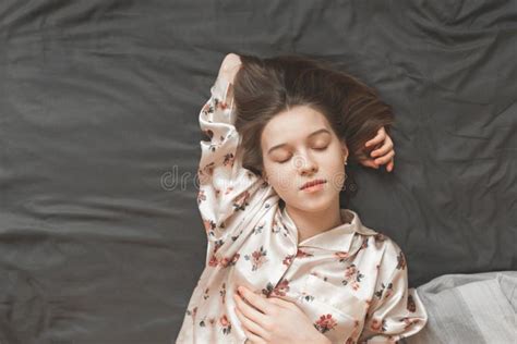 Portrait Of A Young Girl In A Pajama Sleeping On The Bed Top View