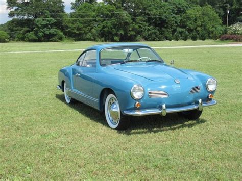 An Old Blue Car Is Parked In The Grass