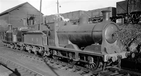 Black And White Photograph Of An Old Steam Engine On The Train Tracks