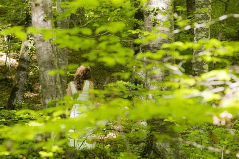 Bride In White Dress Walking Through The Spring Forest In La Fageda D