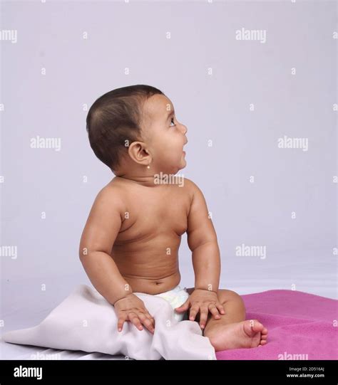 Happy Looking Infant Indian Baby Sitting In A Diaper After Being Oil