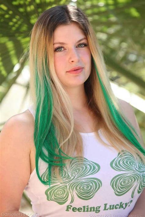 A Woman With Green Hair Is Posing For The Camera