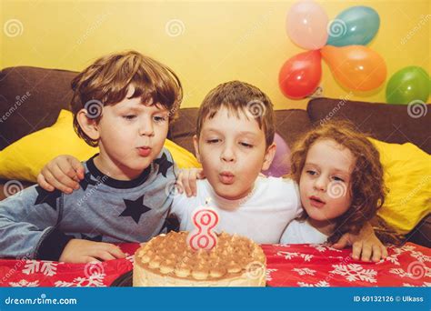 Boy Blows Out The Candles On A Birthday Cake And Hugs His Brothe Stock Photo Image Of Cheerful