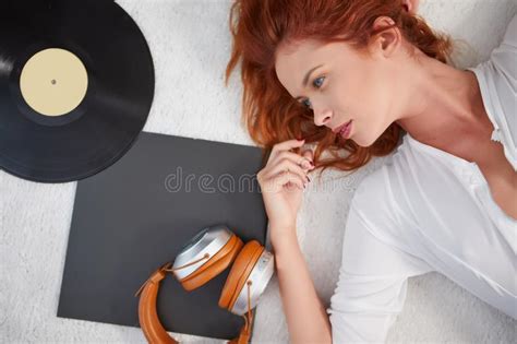 The Girl Is Lying On The Bed Next To Headphones And Vinyl Stock Image