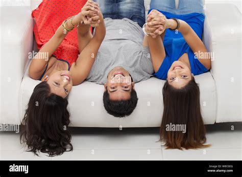 Friends Lying Upside Down On Sofa Stock Photo Alamy
