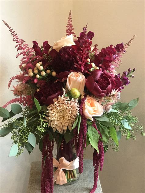 A Vibrant Bouquet Of Burgundy Flowers With Peach Accents To Create This