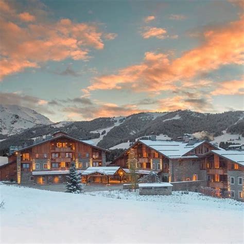 Four Seasons Hotel Megeve Lodge With Lights On Snow Covered Mountain At
