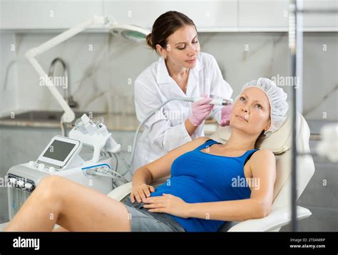 Professional Female Cosmetologist Doing Hydrafacial Procedure In