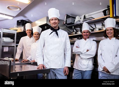 Happy Chefs Team Standing Together In Commercial Kitchen Stock Photo