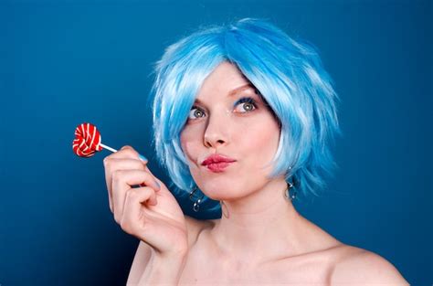 Joyeuse Femme Drôle En Perruque Bleue Avec Une Sucette Dans Les Mains Photo Premium