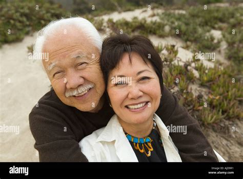 Mature Couple Embracing At Beach Smiling Portrait Stock Photo Alamy
