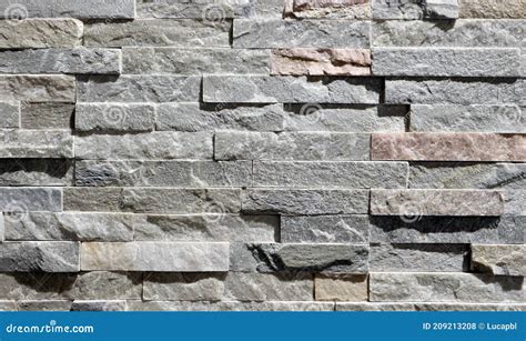 Cladding Wall Made Of Small Uneven Stone Bricks Predominantly Gray