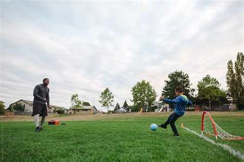Man And Child Father Son Playing Soccer Football Together In By