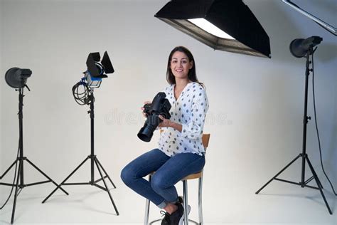 Portrait Of Female Photographer In Studio For Photo Shoot With Camera