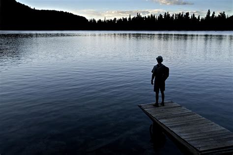 A Man Looking Across A Lake Into Photograph By Dawn Kish
