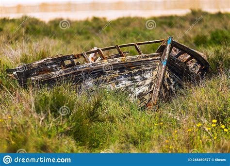 The Wreck Of A Dilapidated Boat On Land Covered With Grass Stock Image